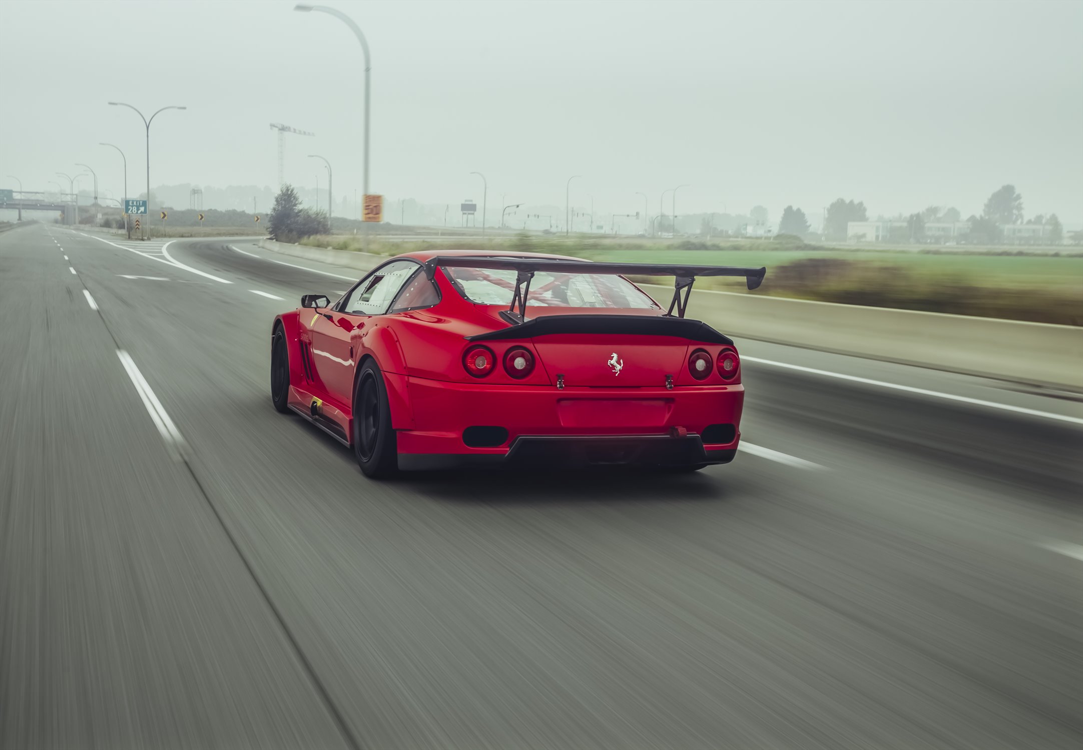 Ferrari 550 Maranello driving from a rear three-quarter view