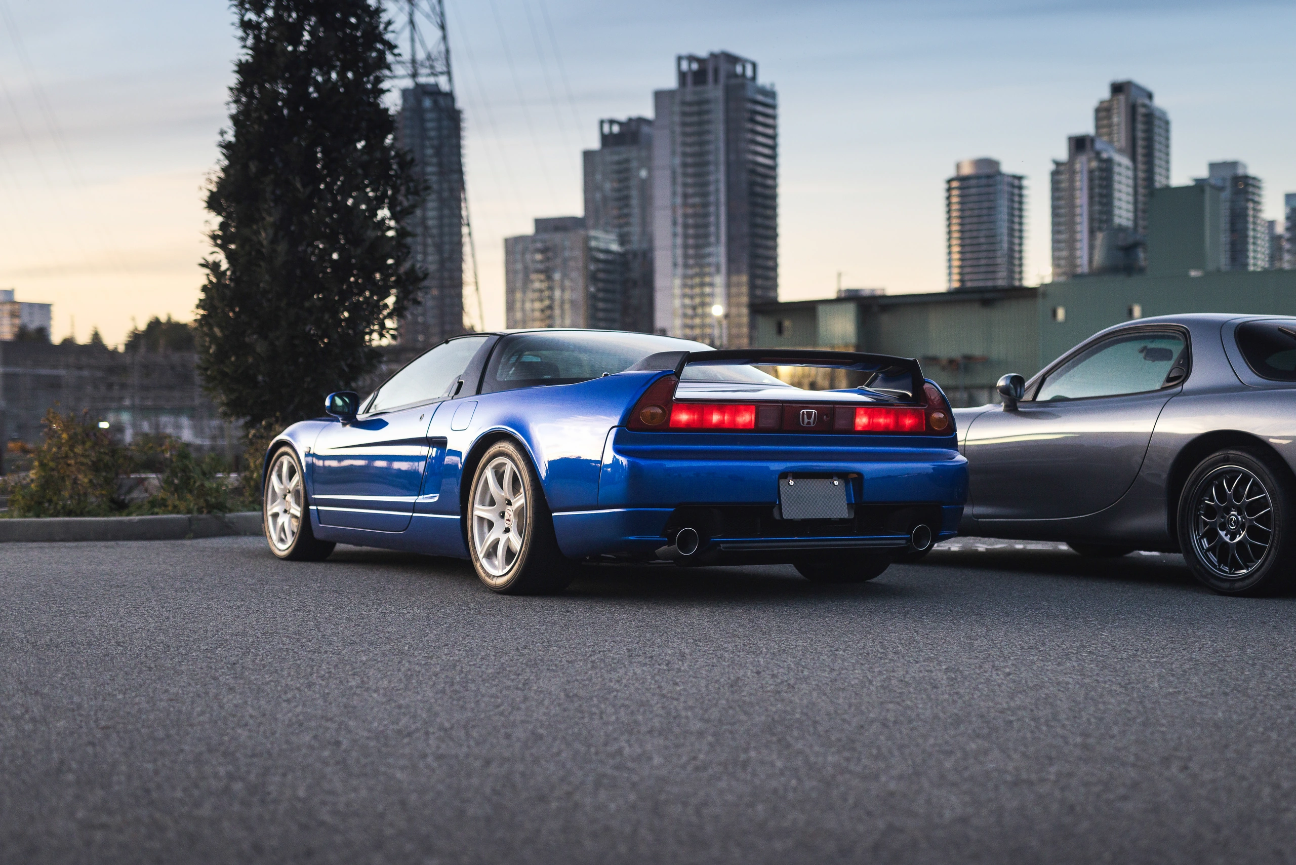Rear three-quarter view of the blue NSX-R, with its distinctive wing and white wheels
