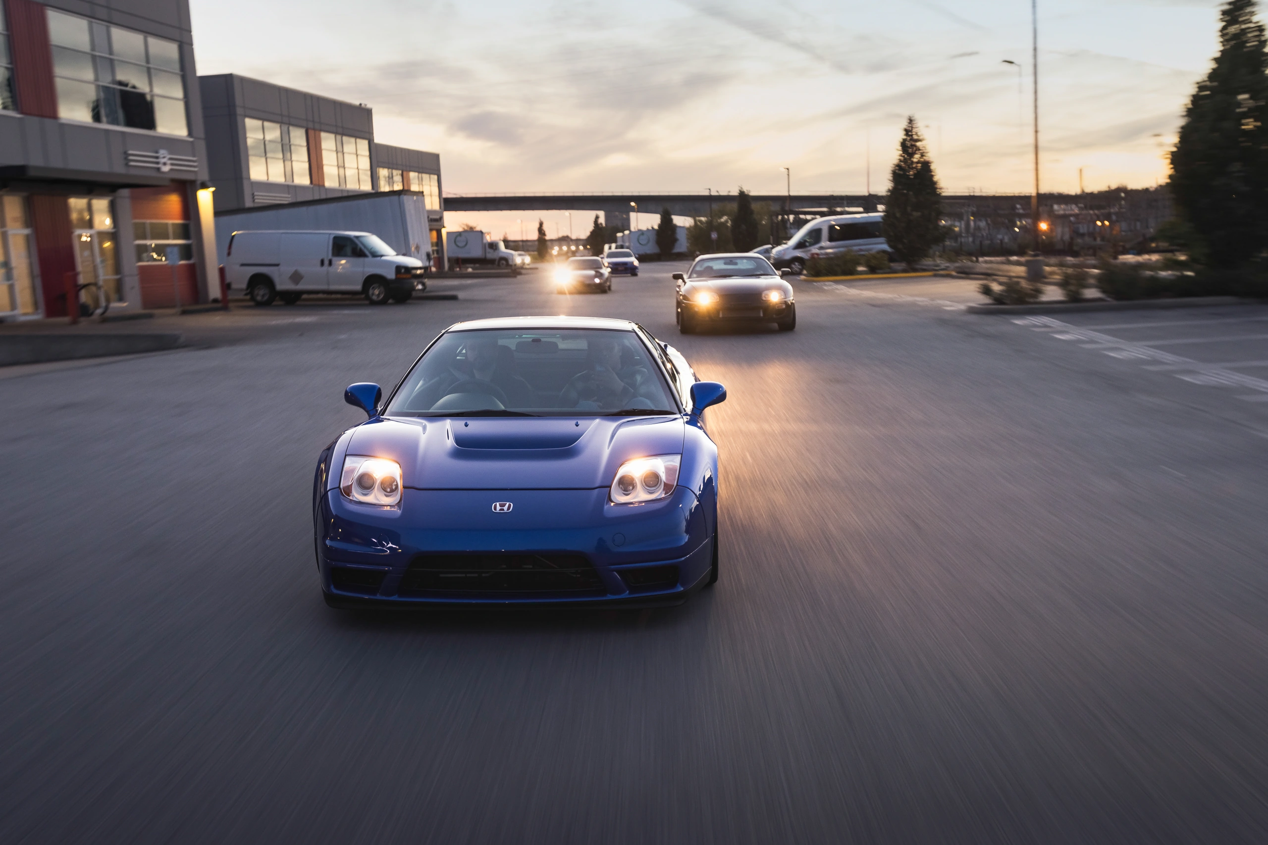 The NSX-R leading the group on the road with its headlamps illuminated