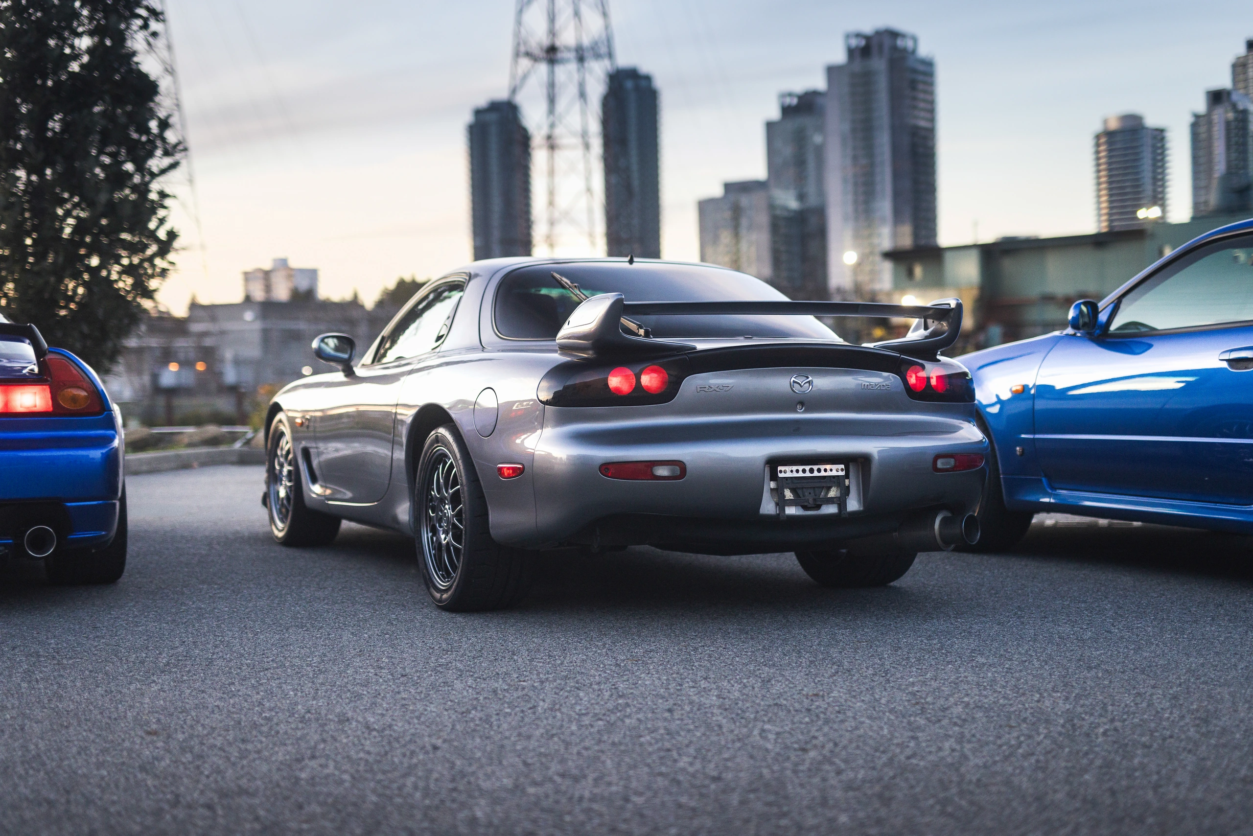 The RX-7 Spirit R's rounded rear bodywork and wing, alongside the blue NSX-R