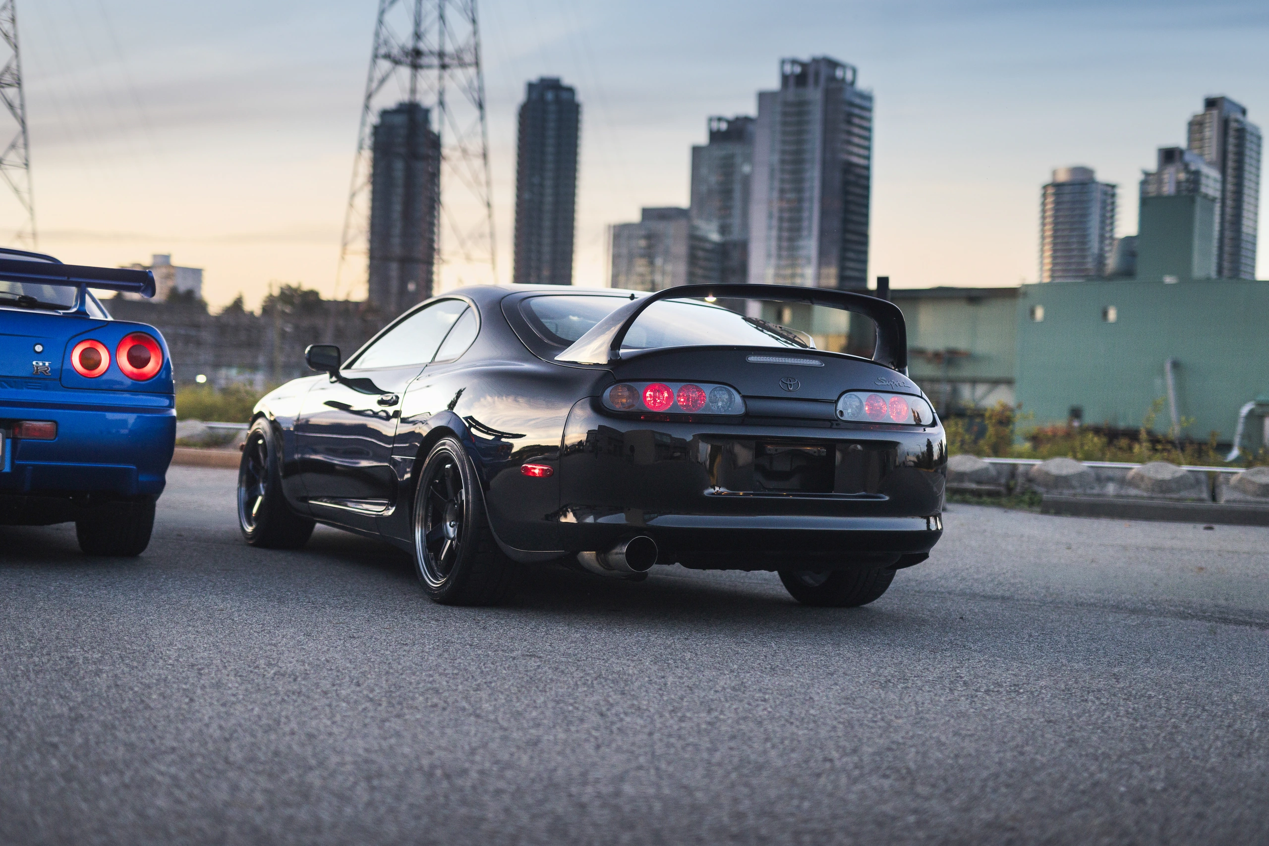 Rear three-quarter view of the black Supra, showing its wing and rounded tail lamps