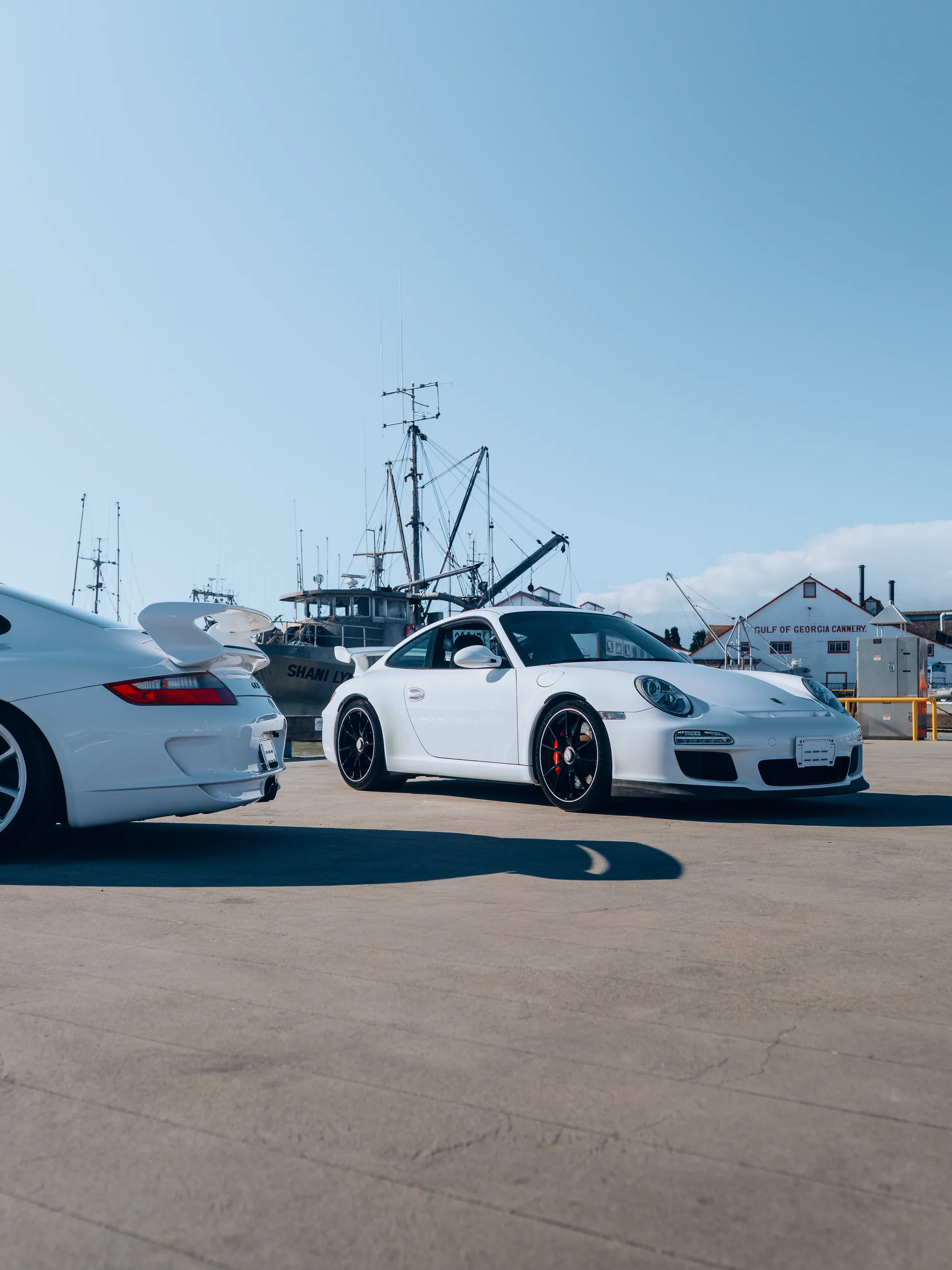 The two white Porsche 911 GT3s at a Japanese harbour