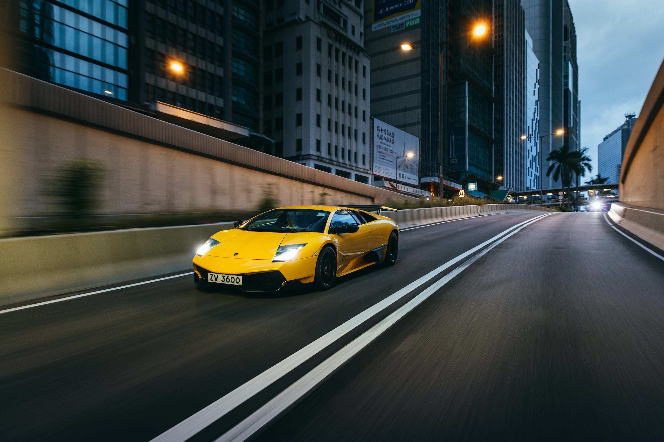 Yellow right-hand-drive Lamborghini Murciélago LP 670-4 SuperVeloce moving through Hong Kong