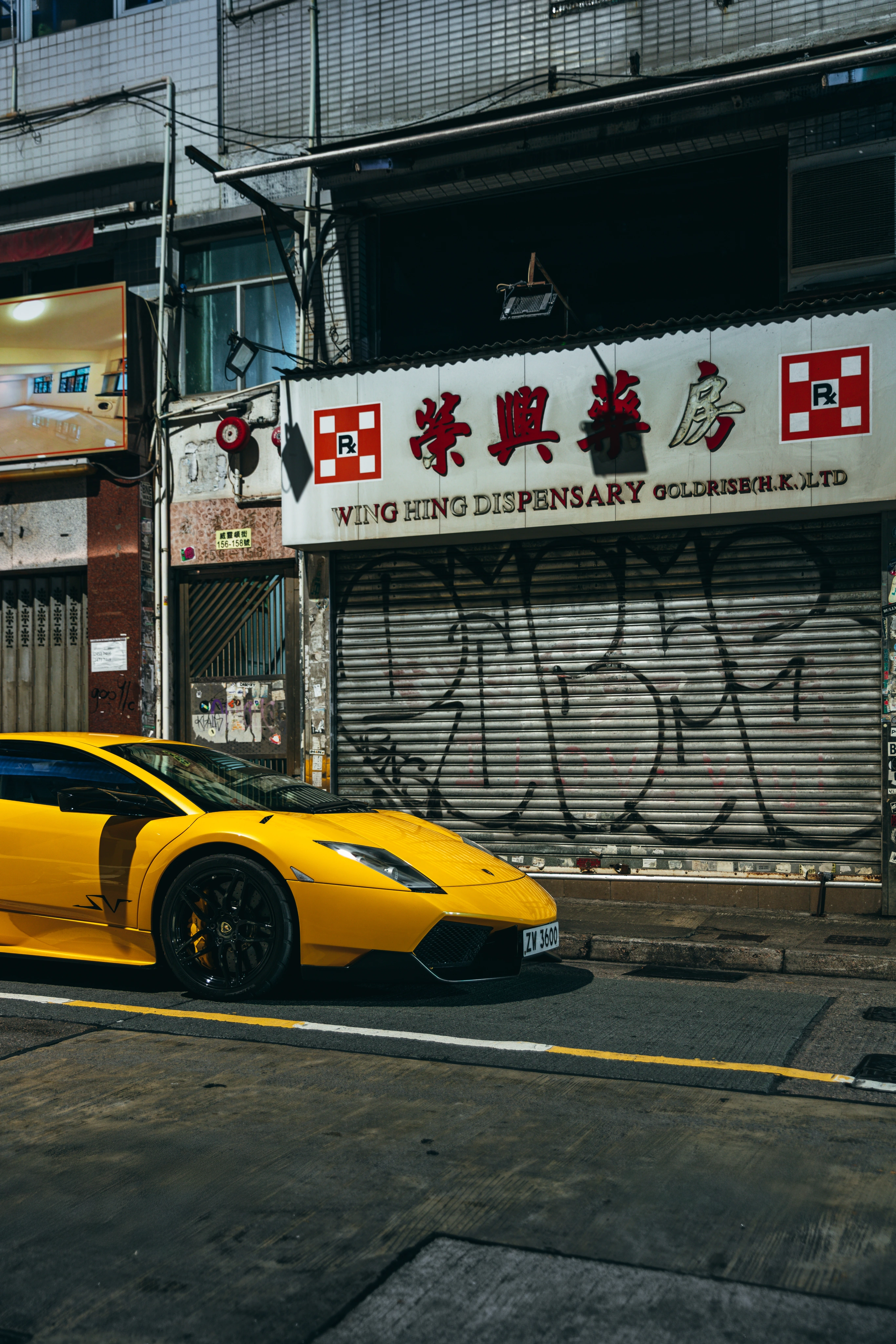 Yellow Murciélago SuperVeloce beneath Hong Kong storefront signage