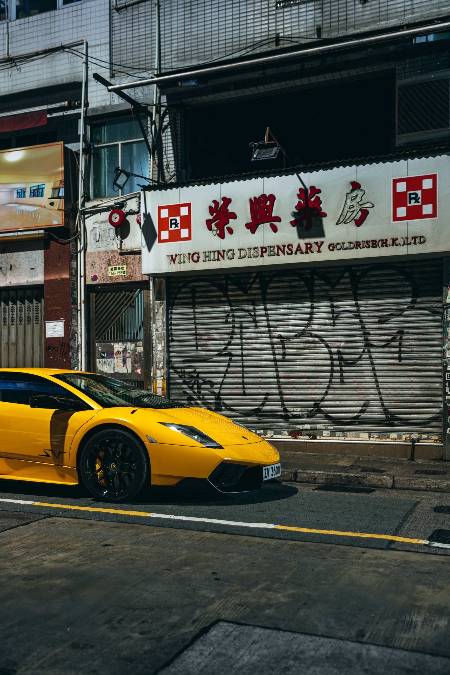 Yellow Murciélago SuperVeloce beneath Hong Kong storefront signage